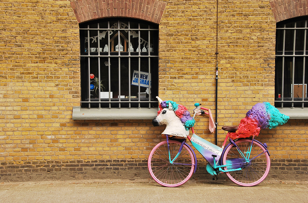 unicorn mask on a bicycle