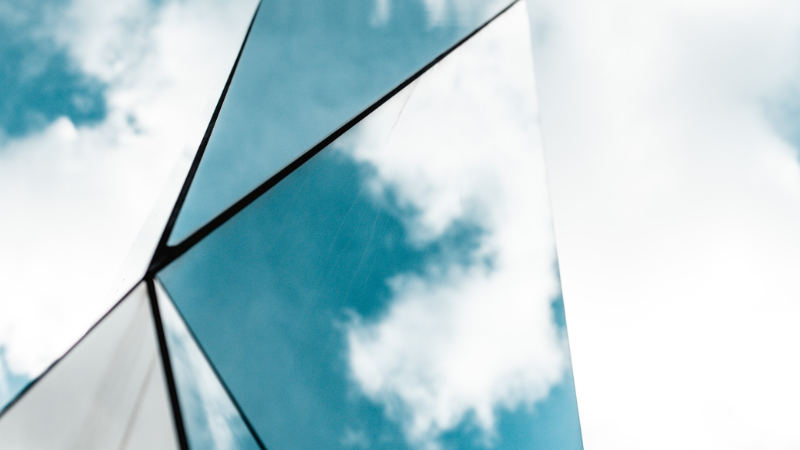 Website_banner_800x450_CFC_AWS – 2 Titelbild Call for Contributions. autonome Waffensysteme. Mehrere spiegelnde Flächen für einem bewölkten Hintergrund.
