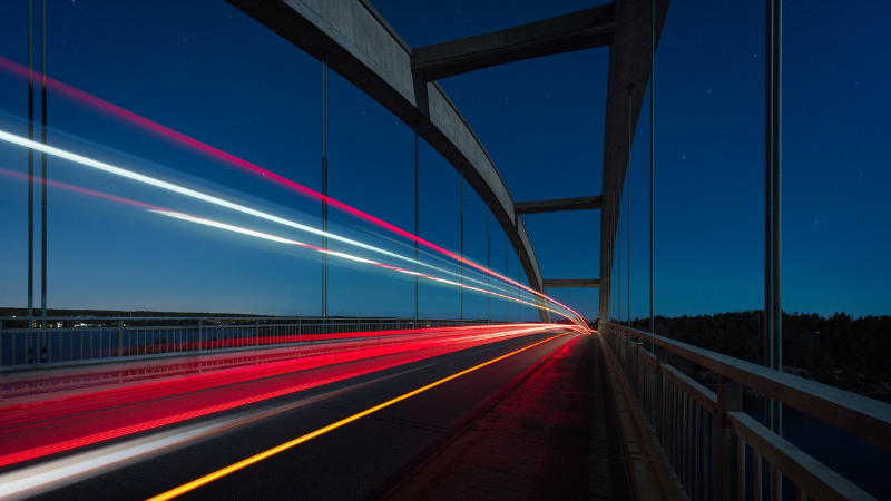 Titelbild Blogpost: Digitalisierung im Mittelstand. Eine Brücke bei Nacht mit Lichtstreifen