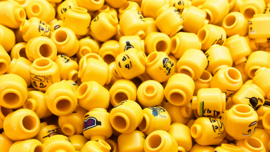 The picture shows many yellow lego heads, symbolising generative AI in recruiting.