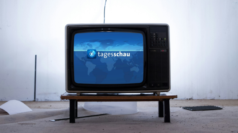 Ein alter schwarzer Röhrenfernseher auf einem Holztisch, der traditionelle Nachrichtensendungen wie die Tagesschau und das neue Format Tagesschau in Einfacher Sprache symbolisiert.