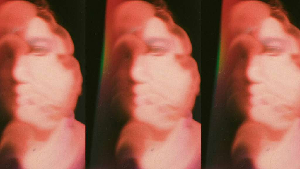 Blurred red face on a dark background symbolizing how AI agents construct digital identity.