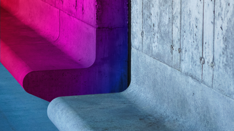 The picture depicts a concrete bench-like structure. Its visible gap serves as a metaphor for structural inequality in AI and gender equality.