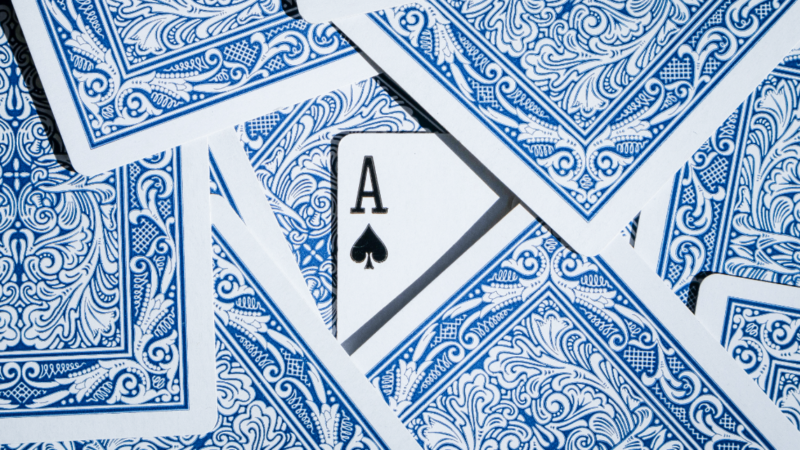 Playing cards on a table with a hidden ace, representing the high-stakes game of platform regulation under the Digital Services Act.