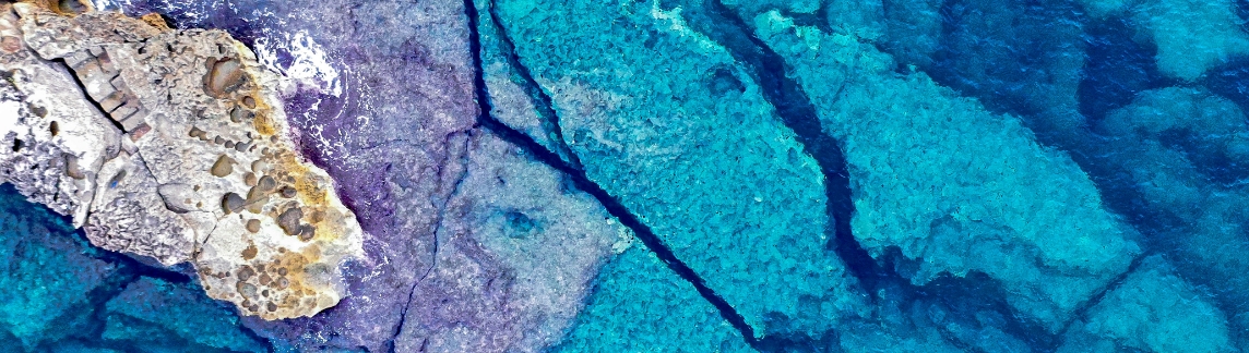 Aerial view of rocks and turquoise sea water