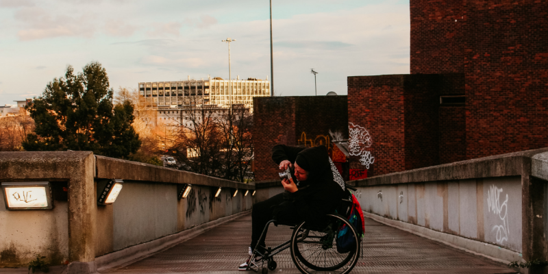 Person in wheelchair taking photos outside