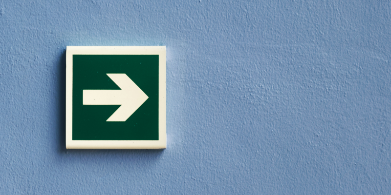 Das Foto zeigt ein Pfeil-Schild an einer Wand, das die zukünftigen Auswirkungen des Gesetzes über digitale Dienste auf die Macht der Plattformen repräsentiert.