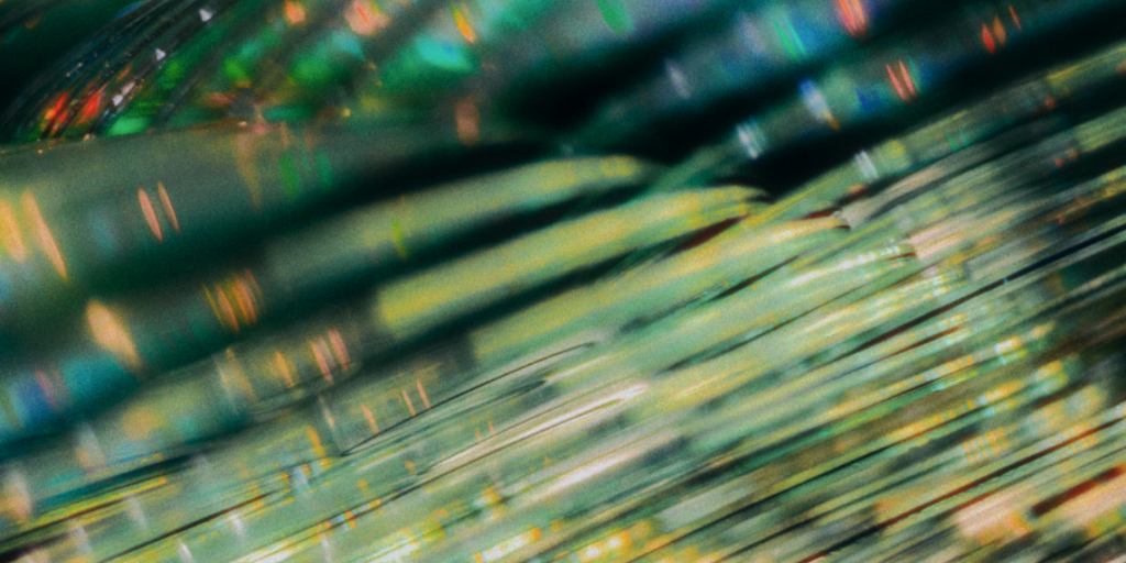 KIStartups_Titelbild Das Bild zeigt ein wellendes Muster aus verschiedenen Farben wie grün, gold und blau, symbolisch für die dynamische KI-Startup Szene.