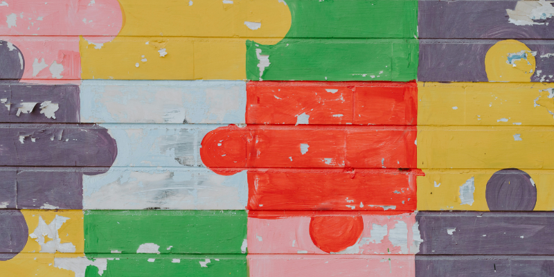 The picture shows colourful puzzle pieces, symbolising that AI for environmental protection is one part of many to protect our planet.