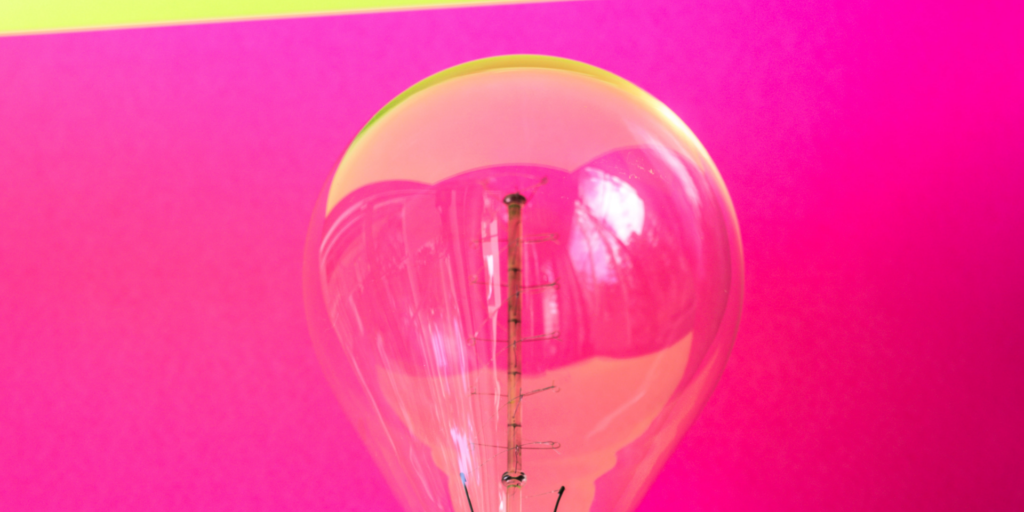 You can see a transparent light bulb in front of a pink background.  