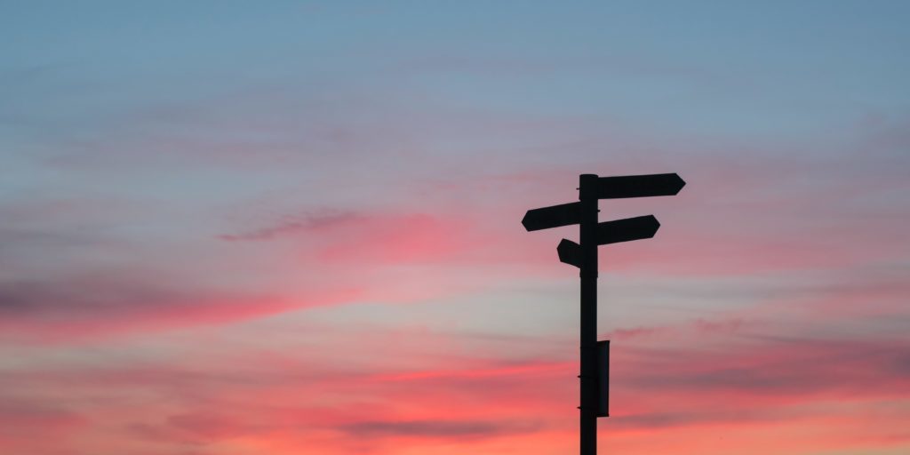 javier-allegue-barros-C7B-ExXpOIE-unsplash Ein Himmel bei Sonnenuntergang, auf dem rechts im Bild ein Wegweiser zu sehen ist
